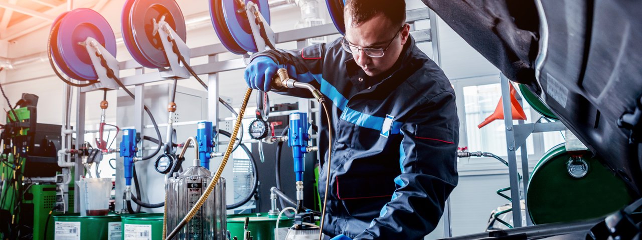 Man in garage cleaning oil